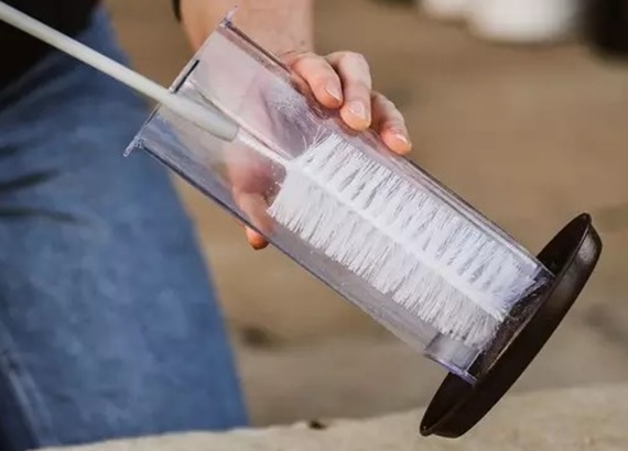 Cleaning a bird feeder with a cleaning brush